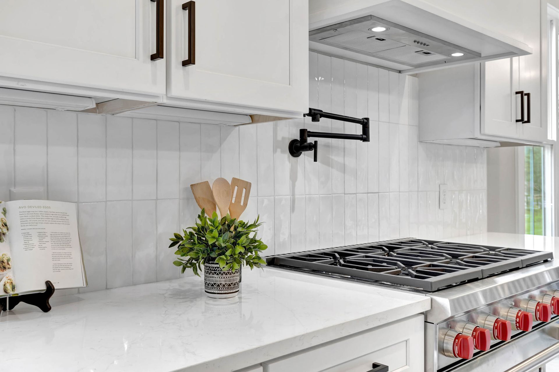 A kitchen with white cabinets and a stove top oven.