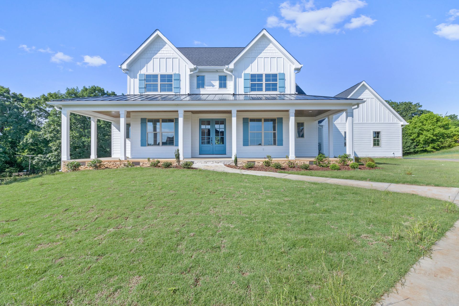 A large white house with a blue front door is for sale.