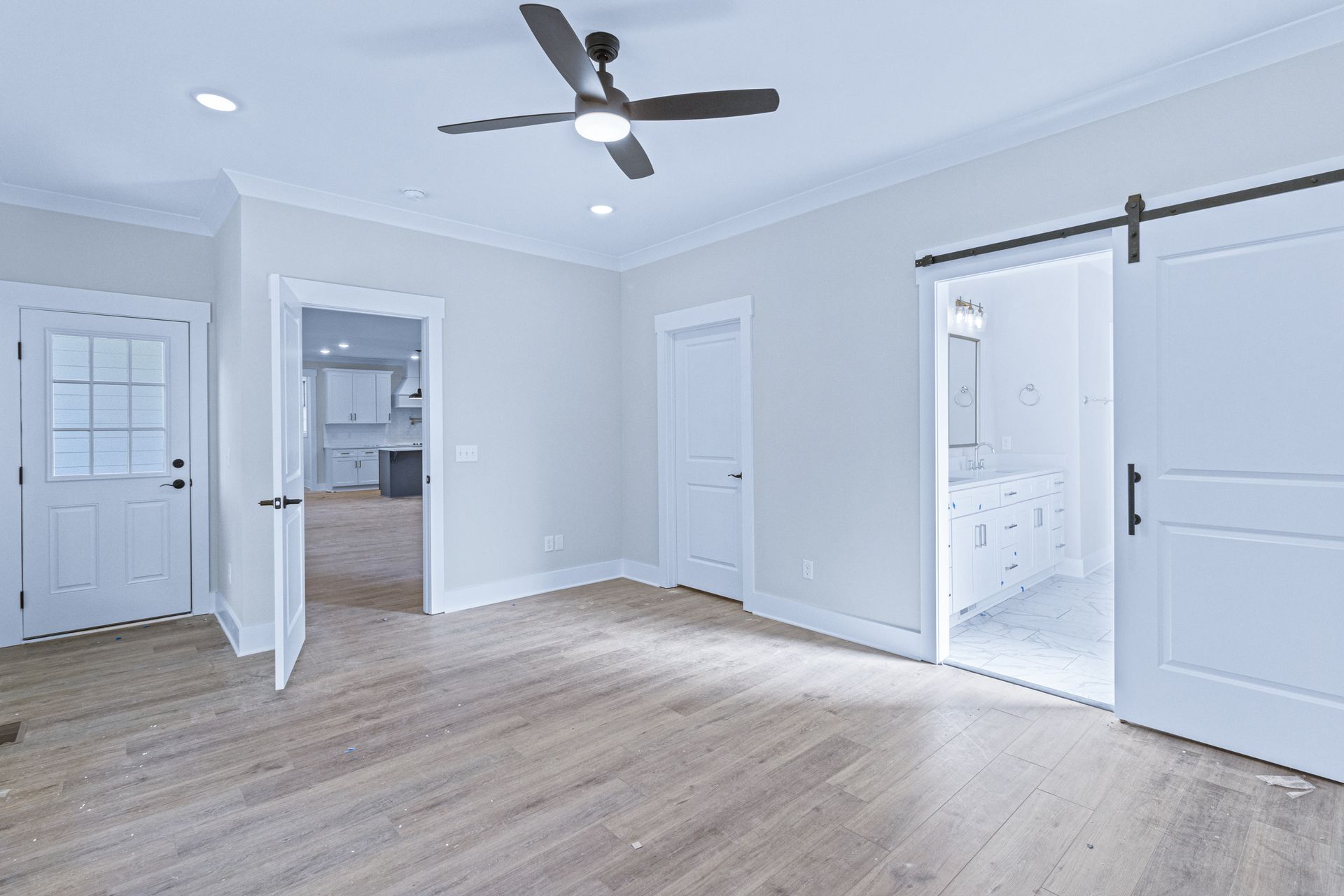 an empty room with a ceiling fan and sliding barn doors .