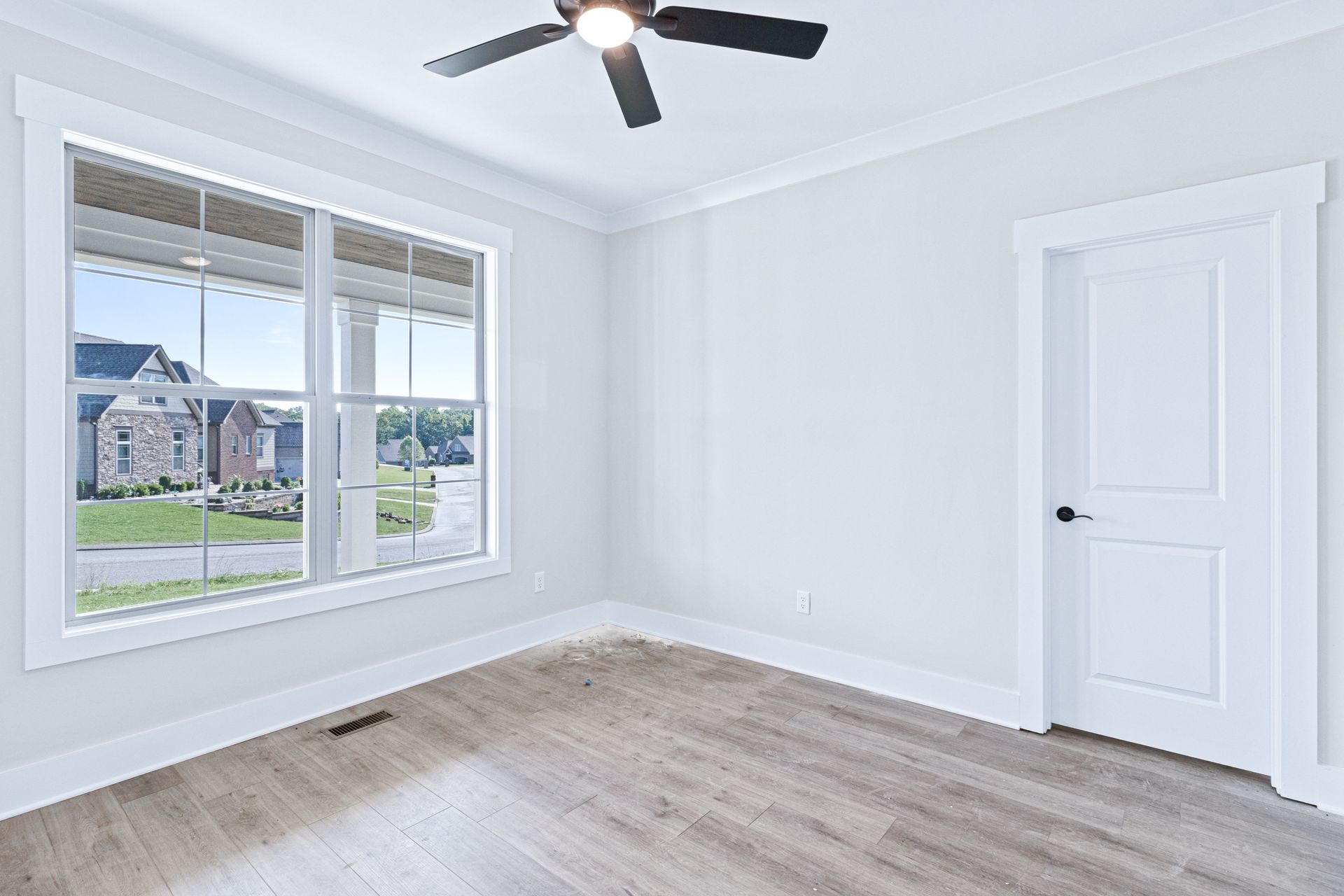 an empty room with hardwood floors and a ceiling fan .