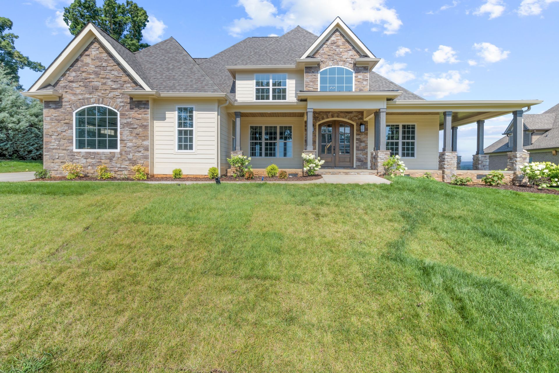 a large house with a lush green lawn in front of it .