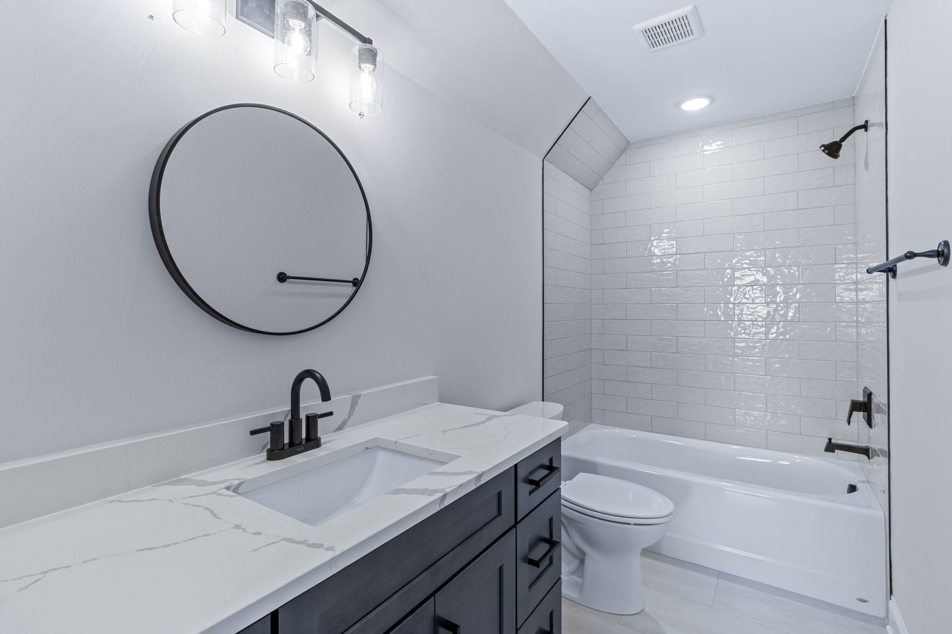 a bathroom with a sink , toilet , bathtub and mirror .