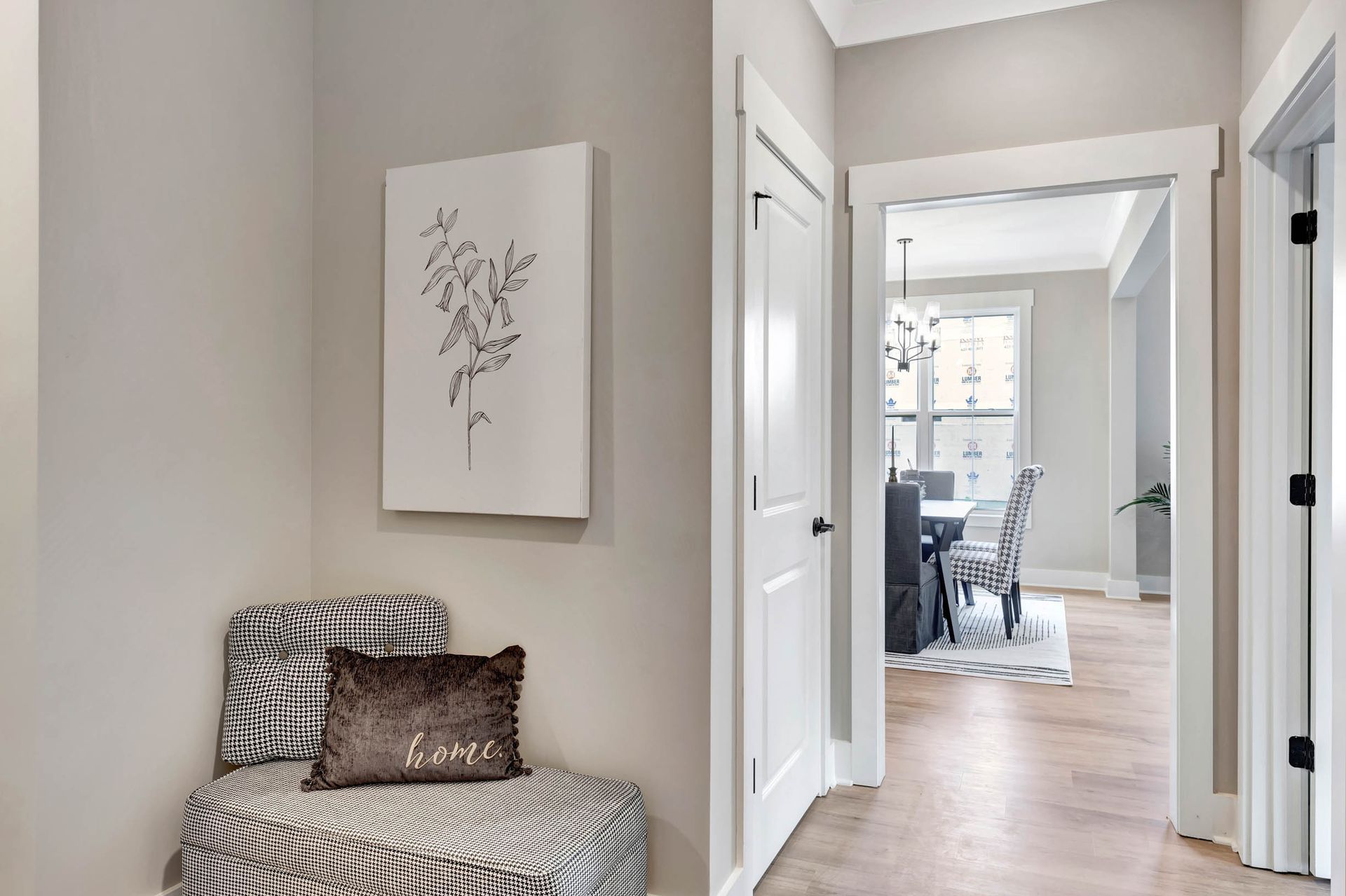 A hallway with a bench and a painting on the wall.