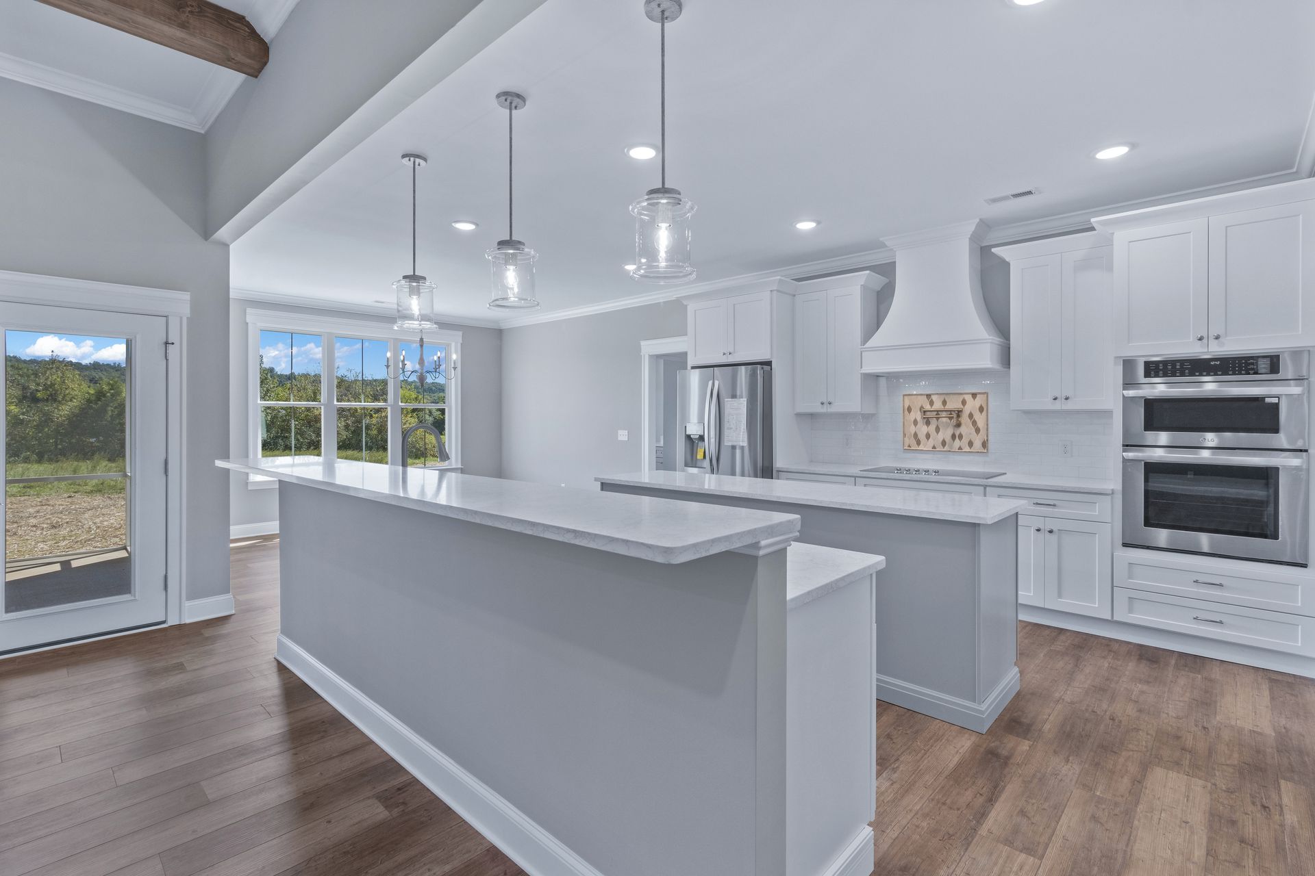 a kitchen with white cabinets and stainless steel appliances and a large island .