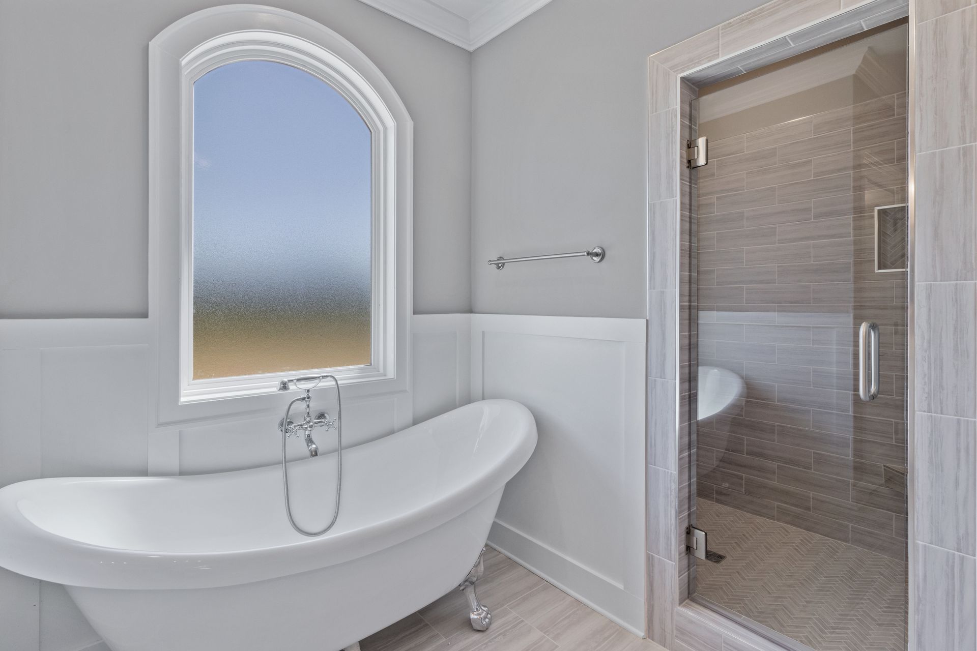 a bathroom with a tub , shower , and window .