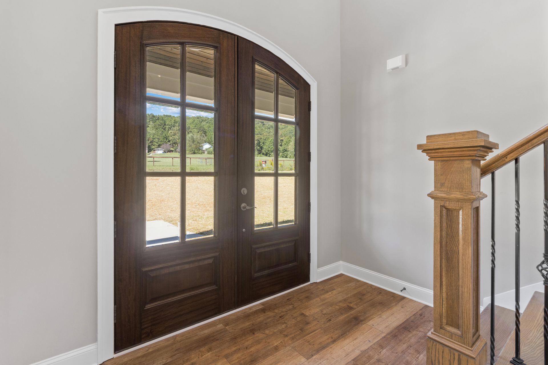 there is a staircase leading up to the second floor with a wooden railing and a wooden door .