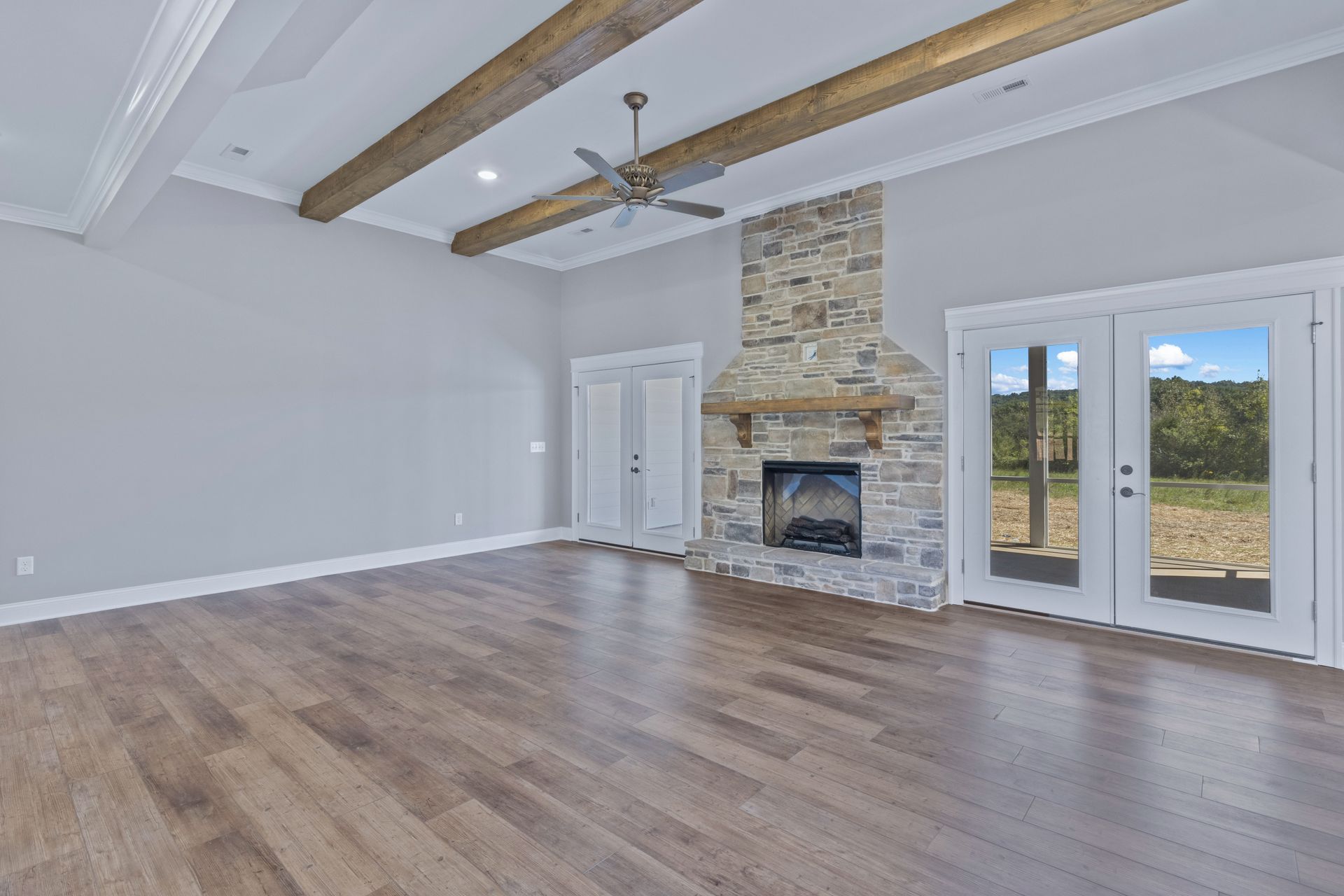 an empty living room with hardwood floors and a fireplace .