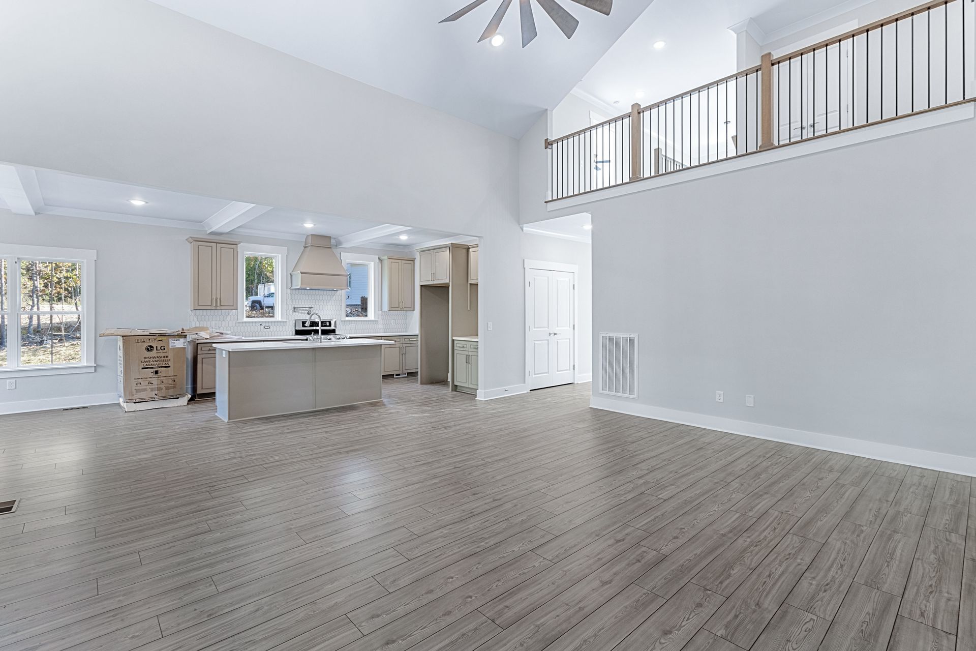 a large empty room with hardwood floors and a ceiling fan .