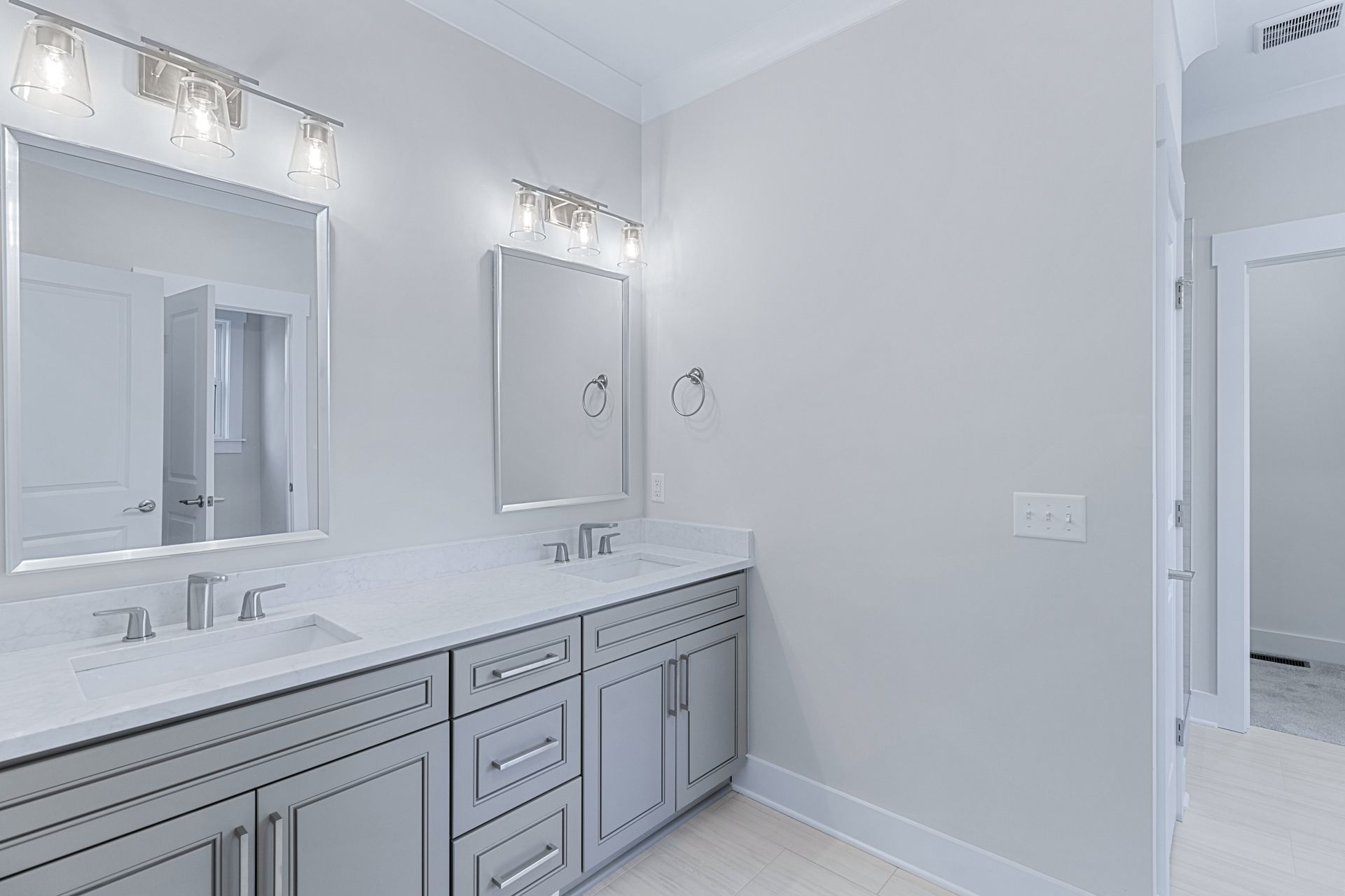 a bathroom with two sinks and two mirrors .