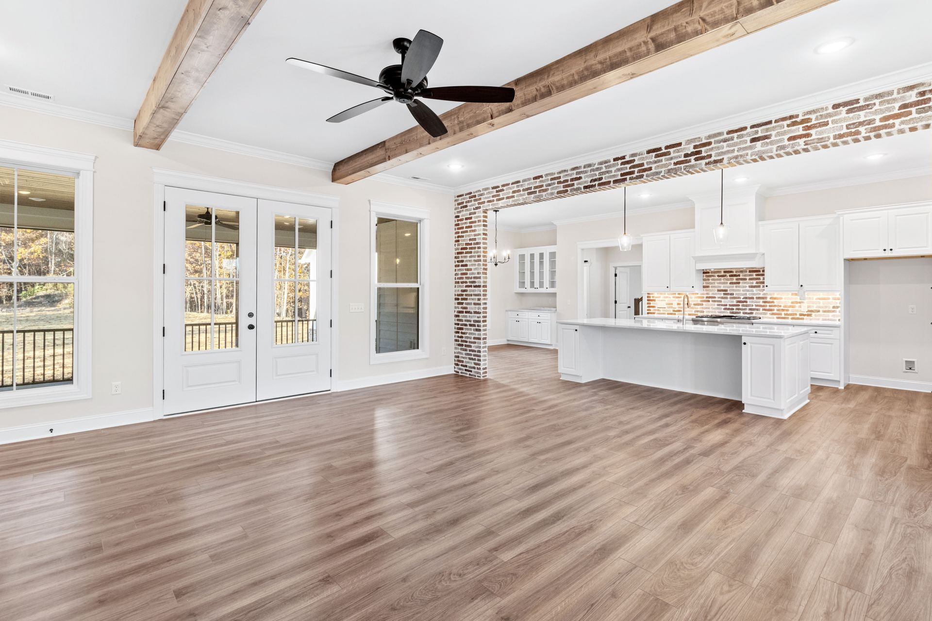 an empty living room with hardwood floors and a ceiling fan .