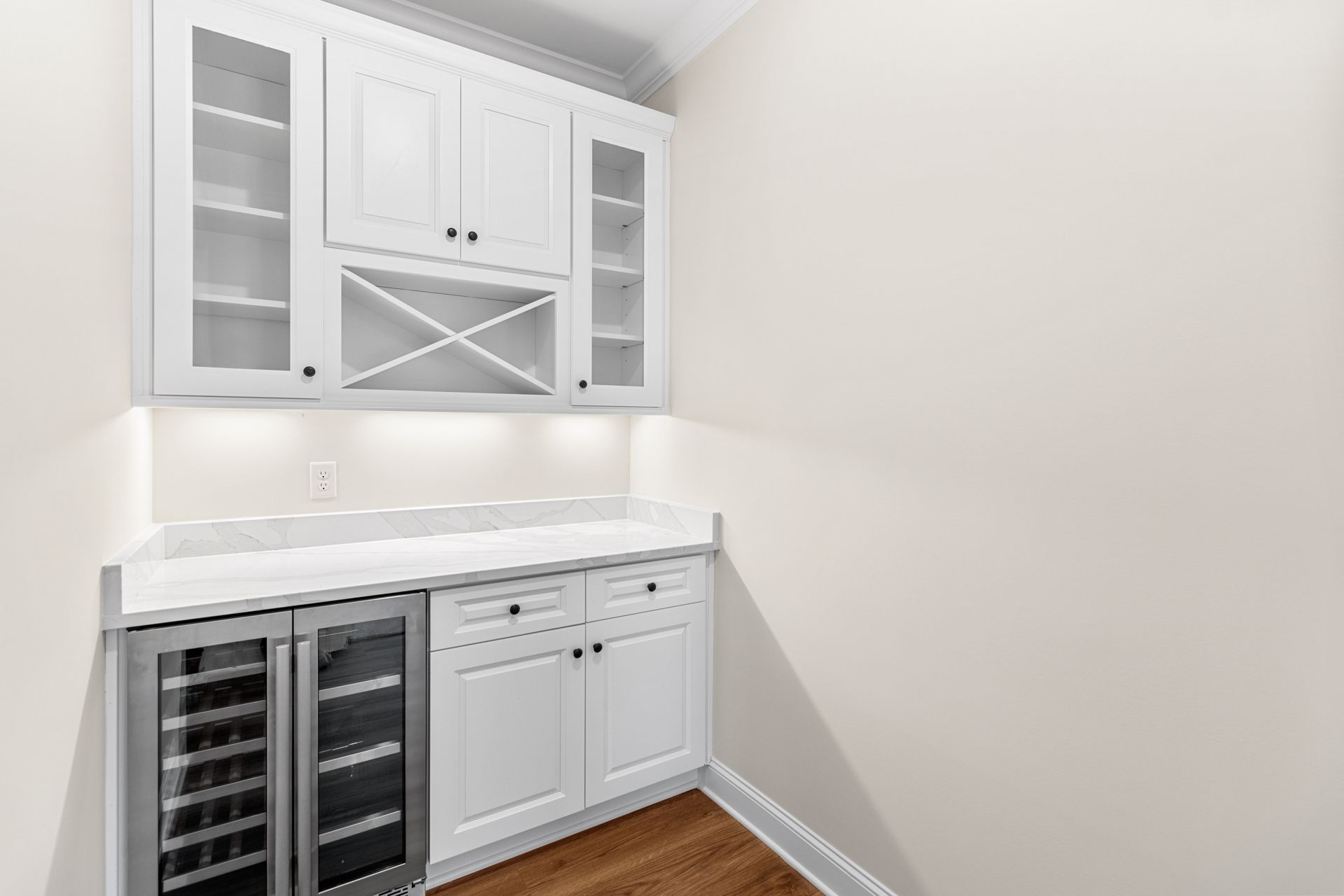 a kitchen with white cabinets and a wine cooler .