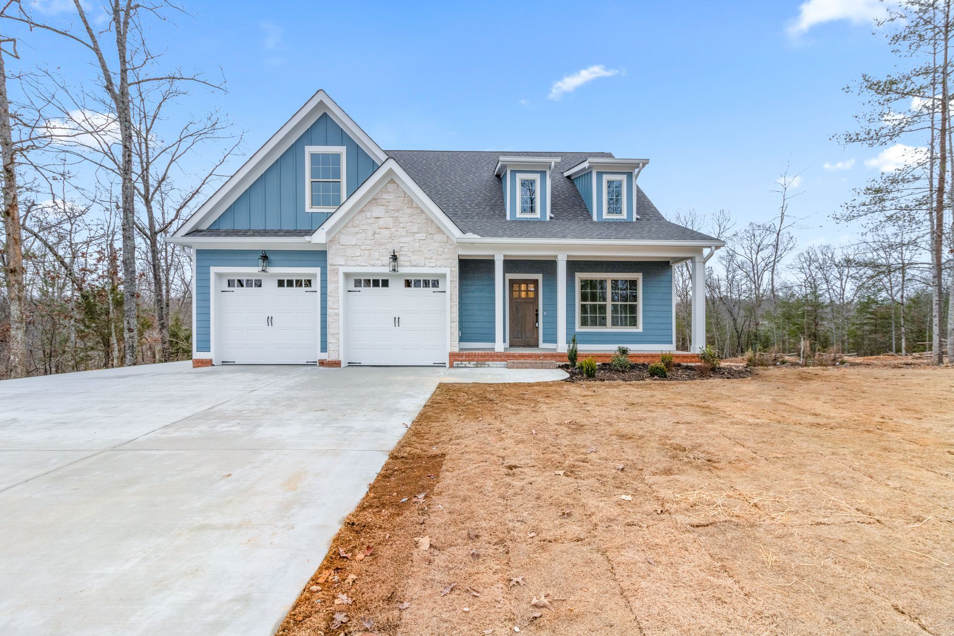 a blue and white house with a garage and a driveway