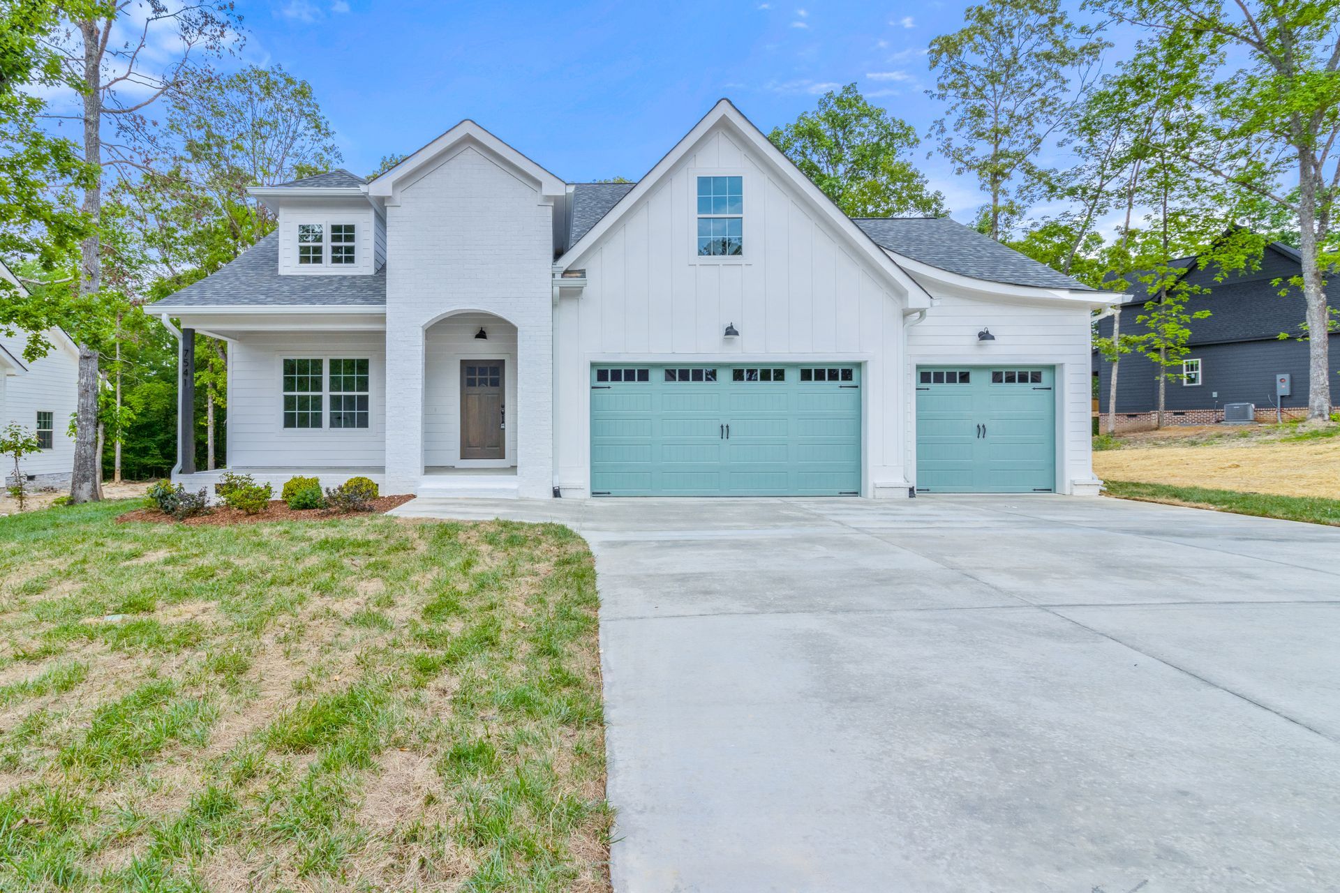a white house with blue garage doors is for sale .