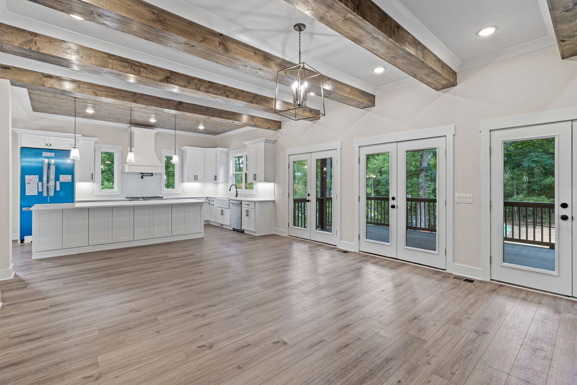 A large empty room with hardwood floors and wooden beams.