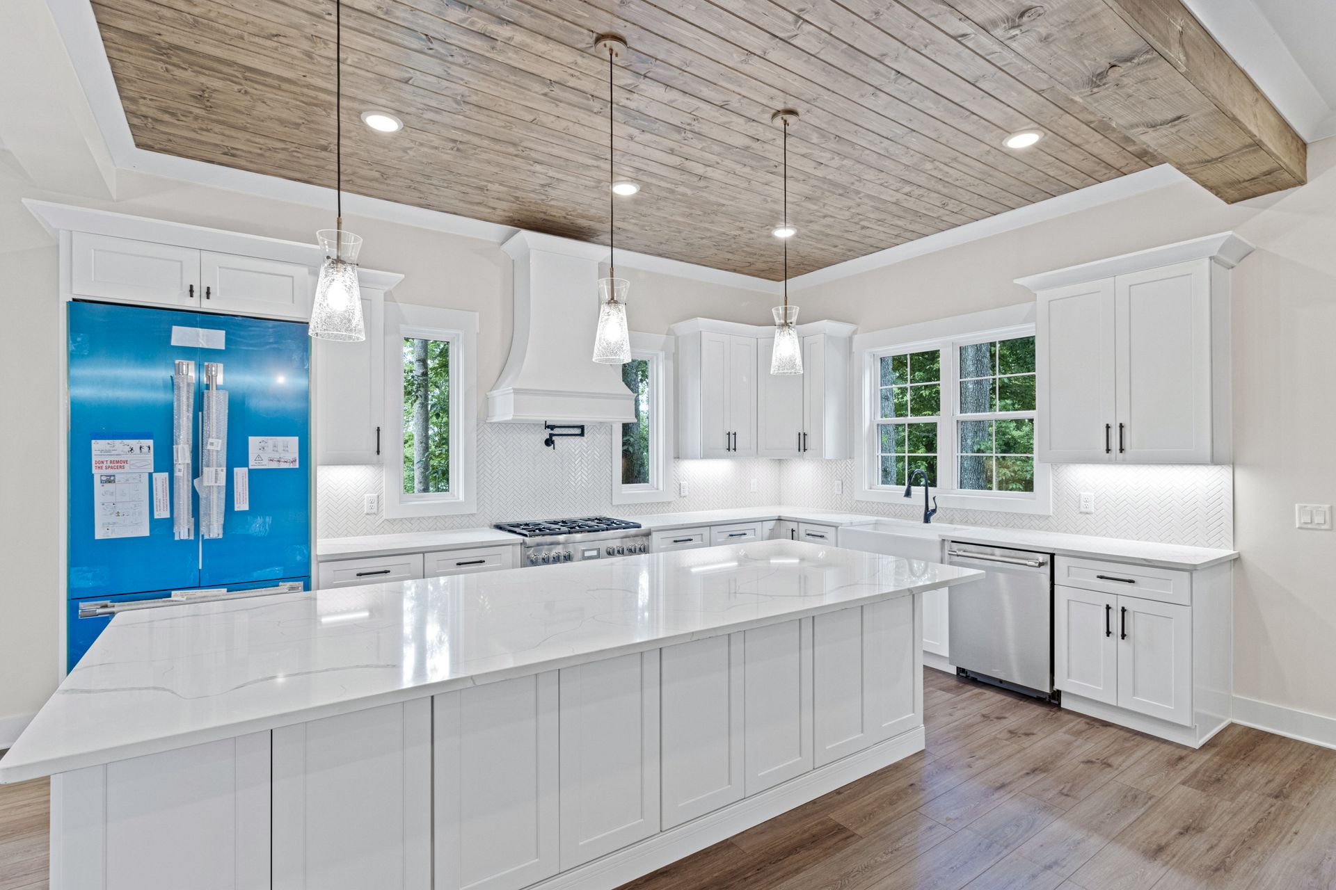 a kitchen with white cabinets and a blue refrigerator .