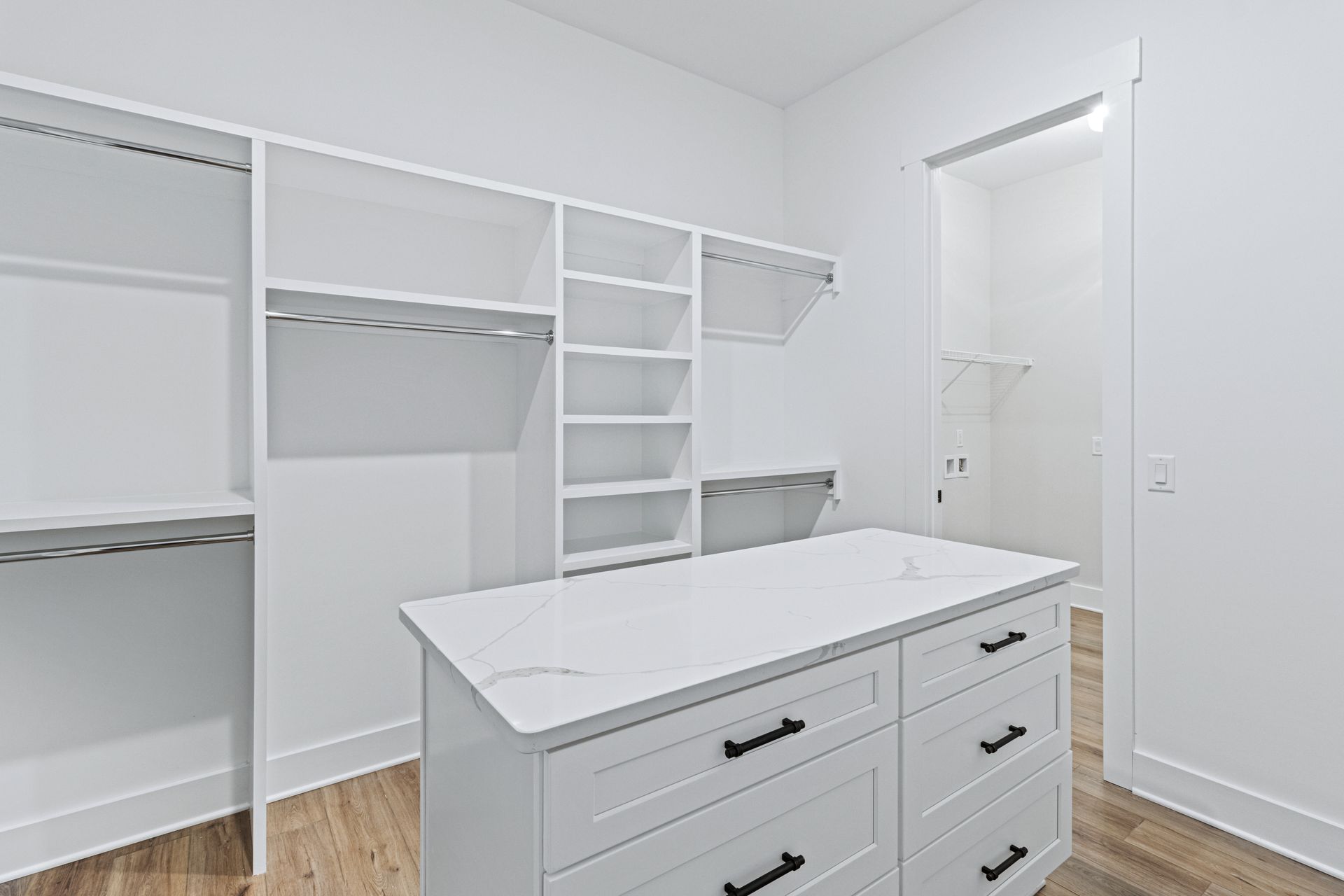 a walk in closet with a large island in the middle .