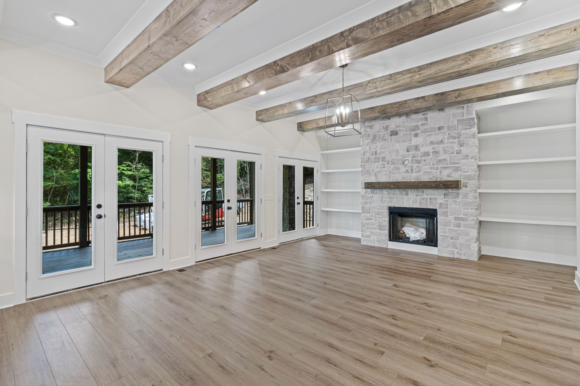 an empty living room with hardwood floors and a fireplace .