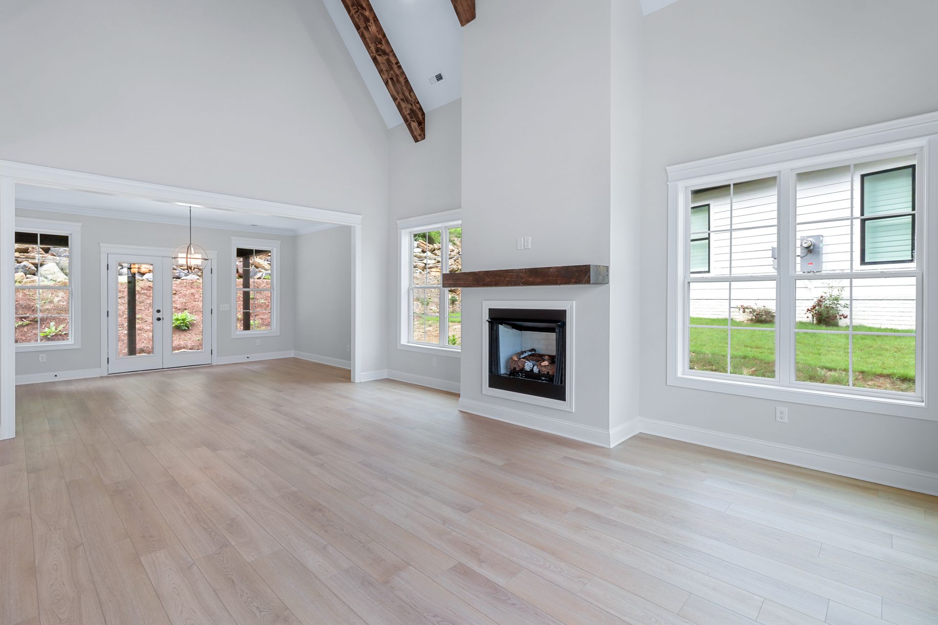 an empty living room with hardwood floors and a fireplace .