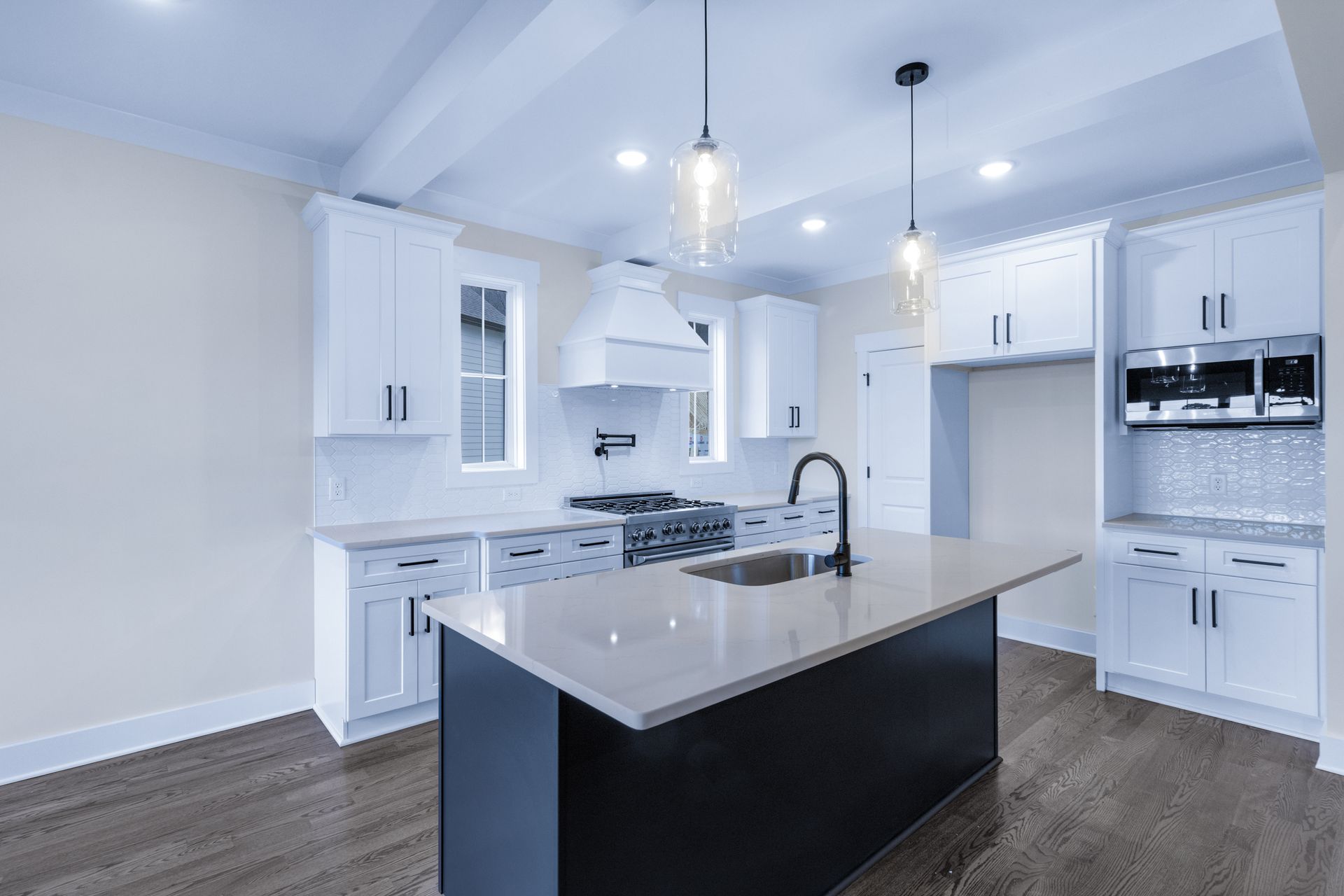 a kitchen with white cabinets and a large island in the middle .