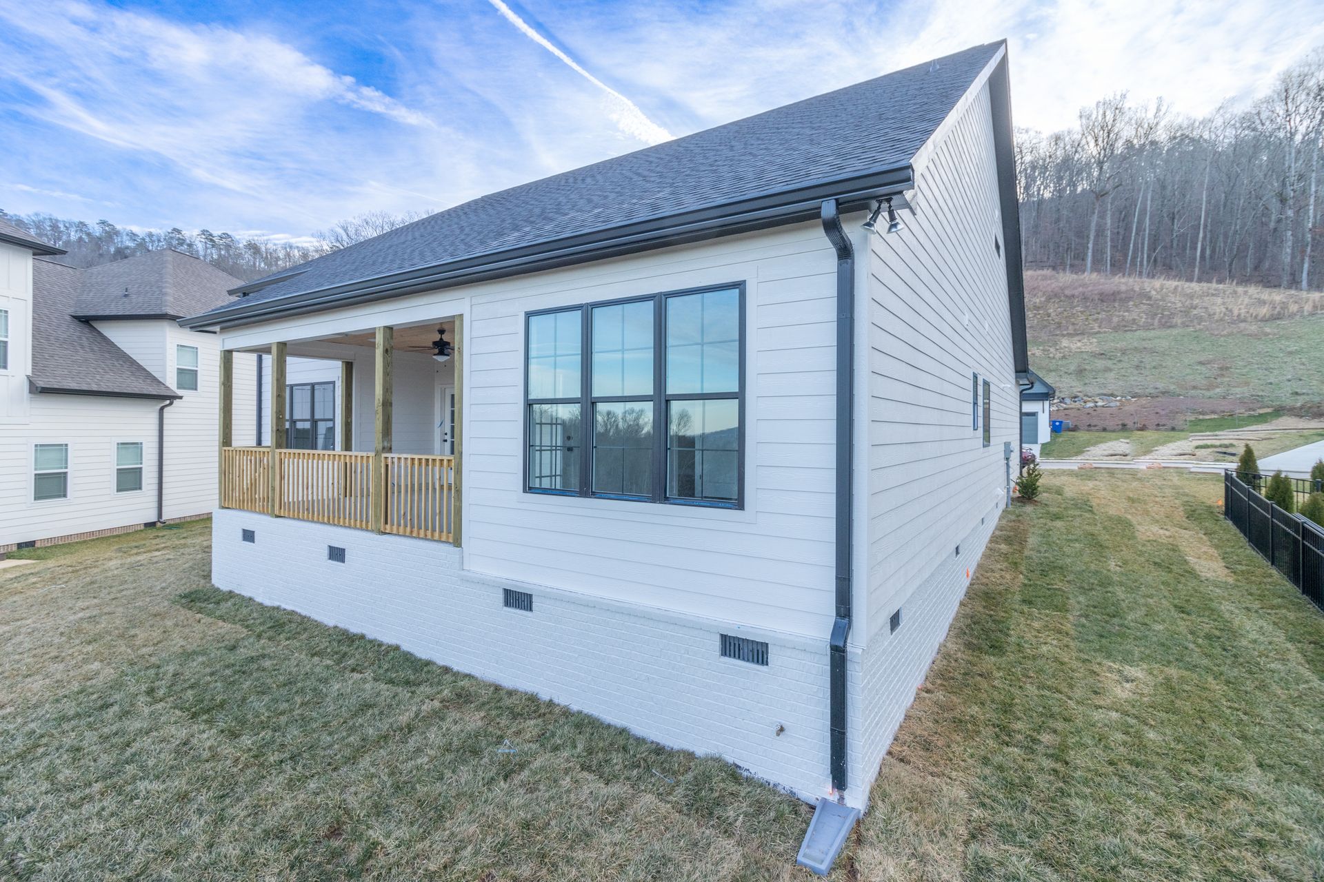 a large white house with two garages and a concrete driveway .