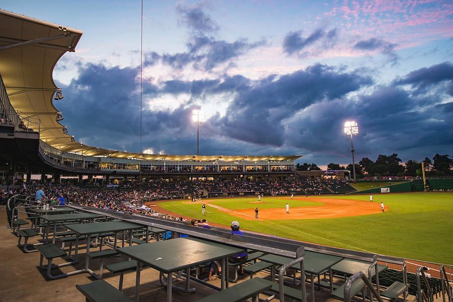 A baseball stadium with tables and benches in the outfield.