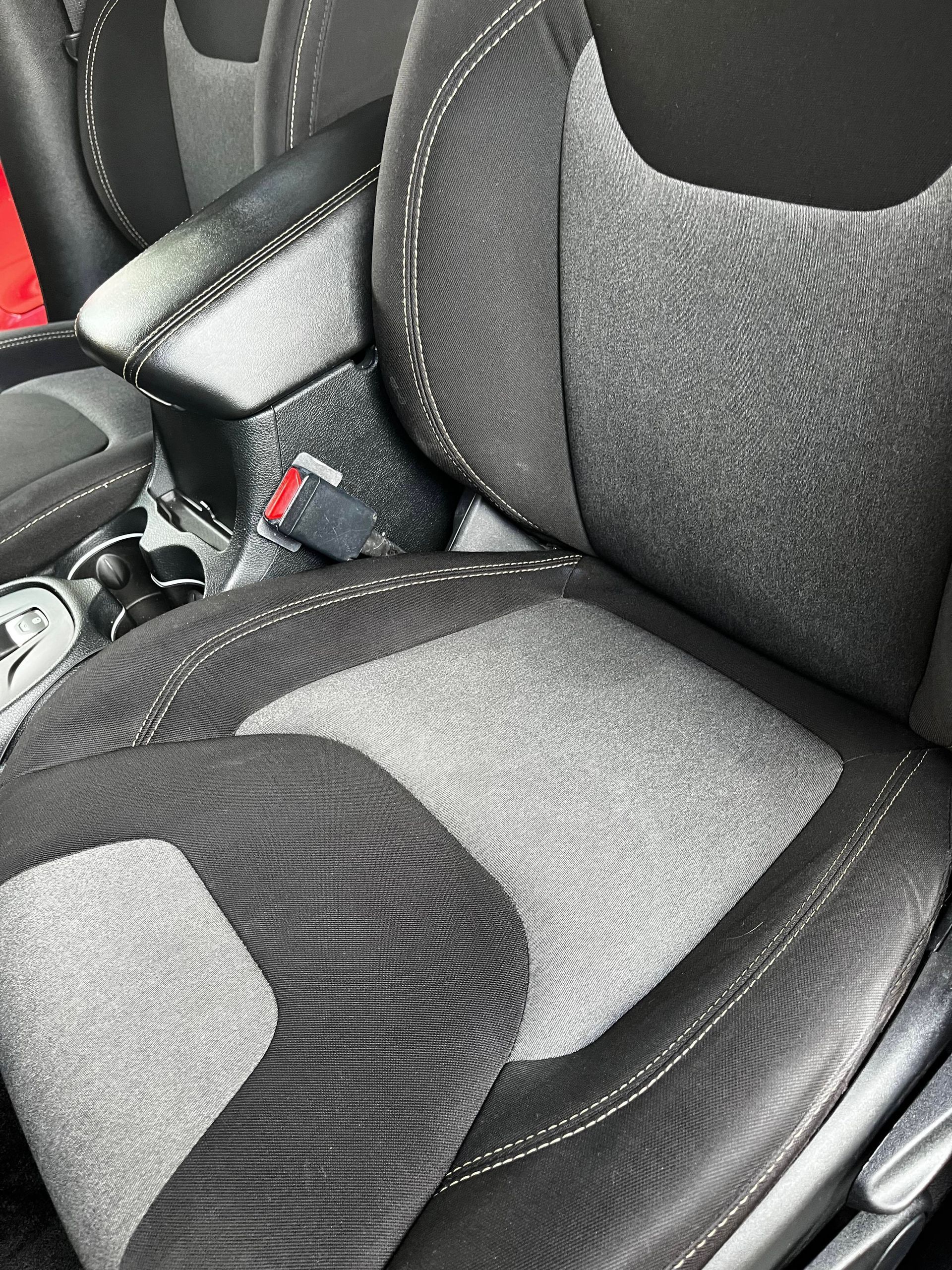 A shiny red Ram pickup truck parked on a driveway in front of a house.