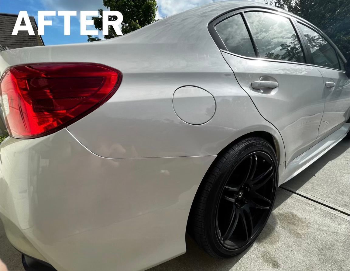 White Subaru sedan, black wheels, shiny finish, parked outdoors.