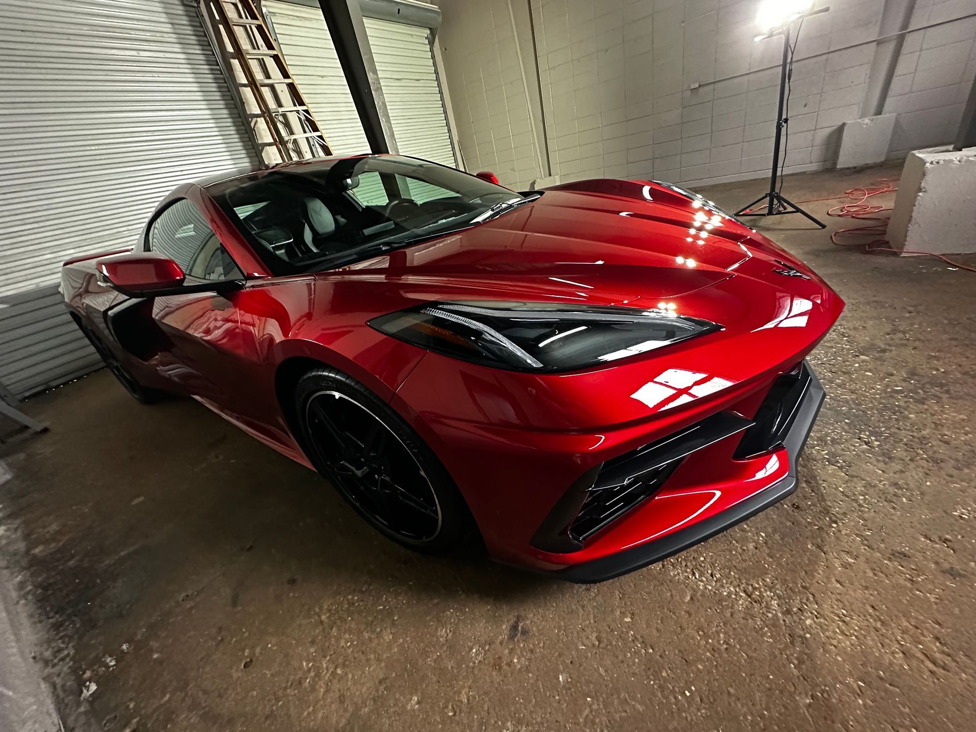 Red sports car inside a garage.