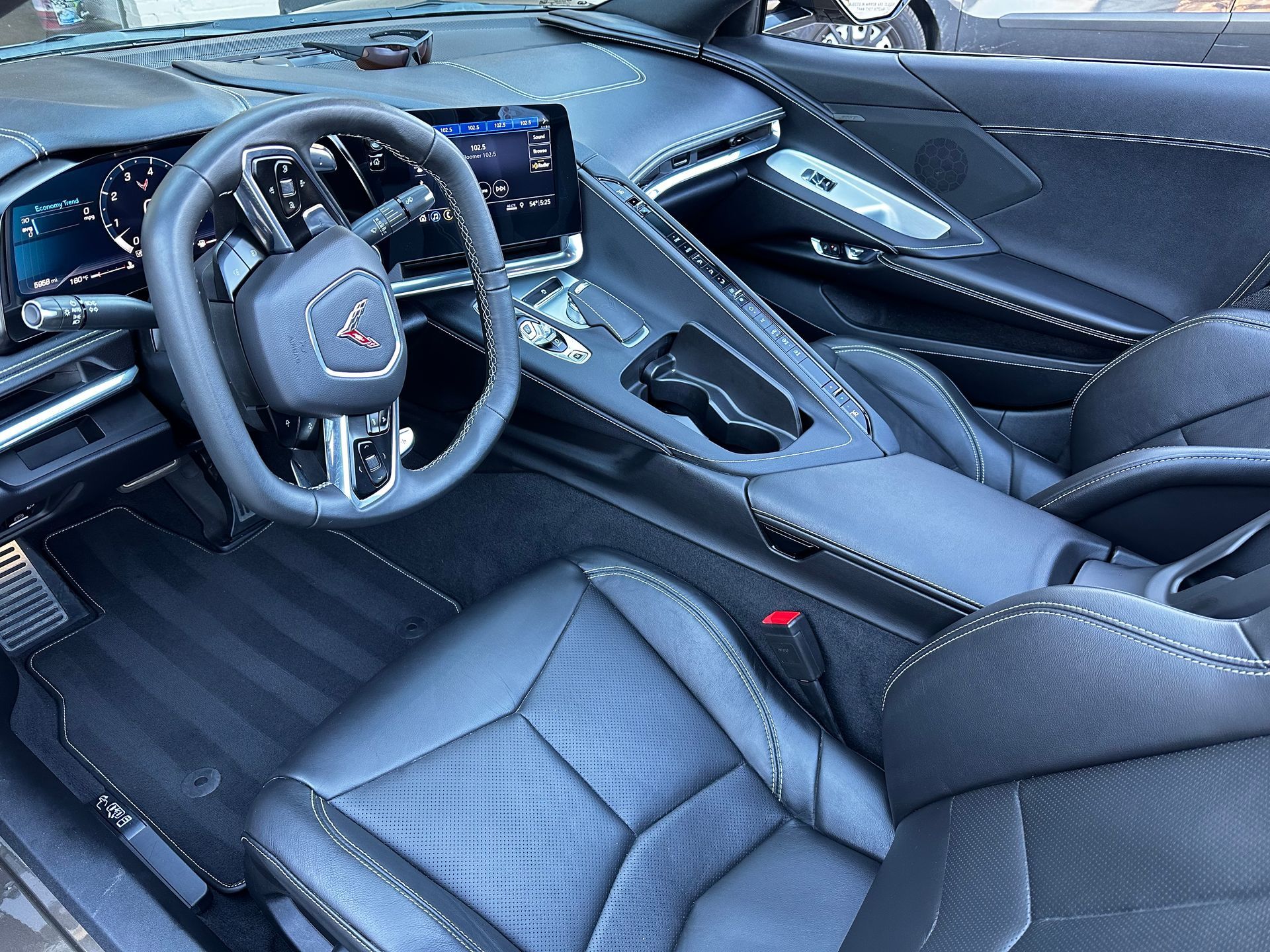 Black interior of a Corvette sports car, leather seats, steering wheel, and dashboard.
