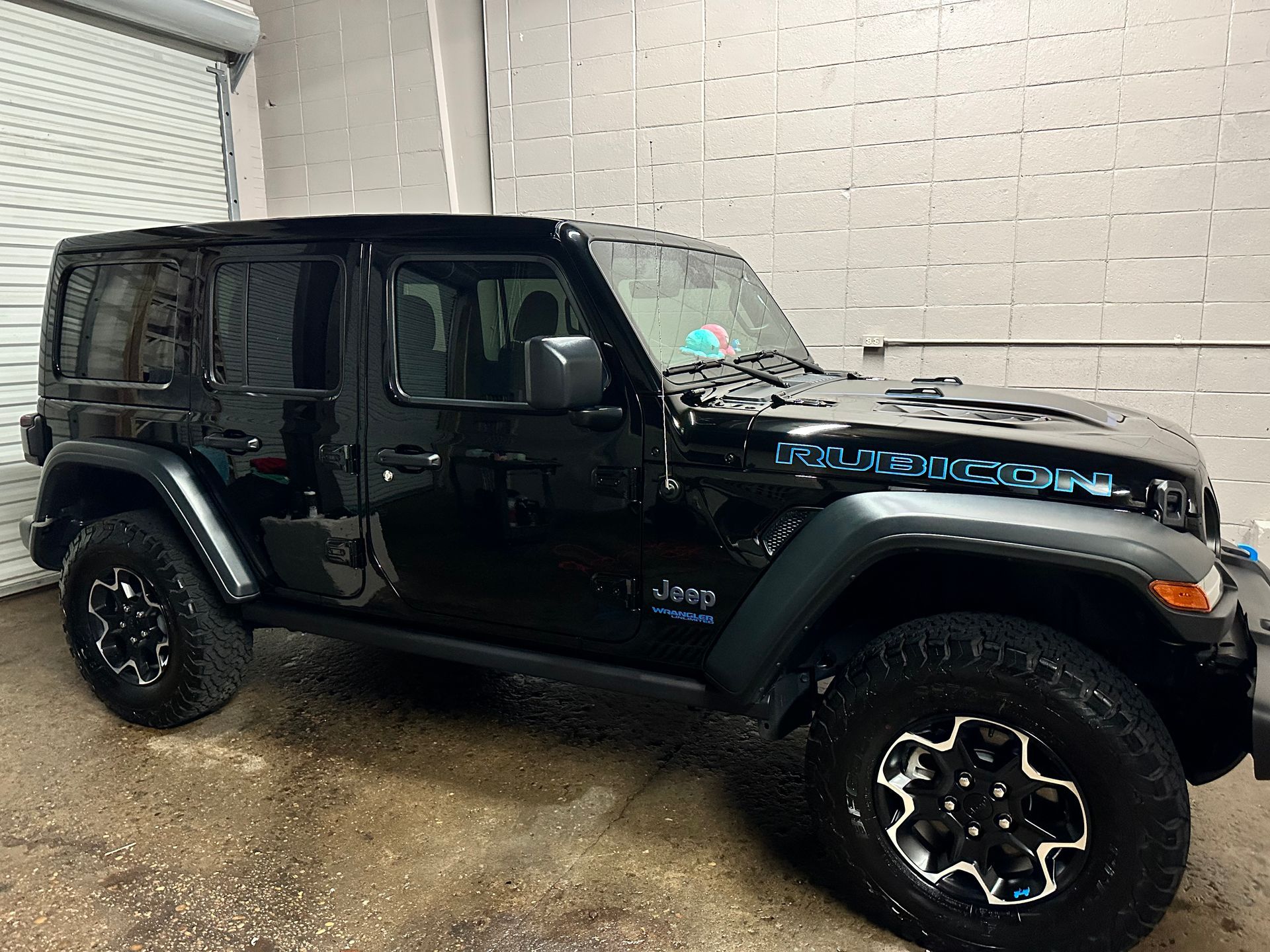 Black Jeep Wrangler Rubicon parked inside a garage.
