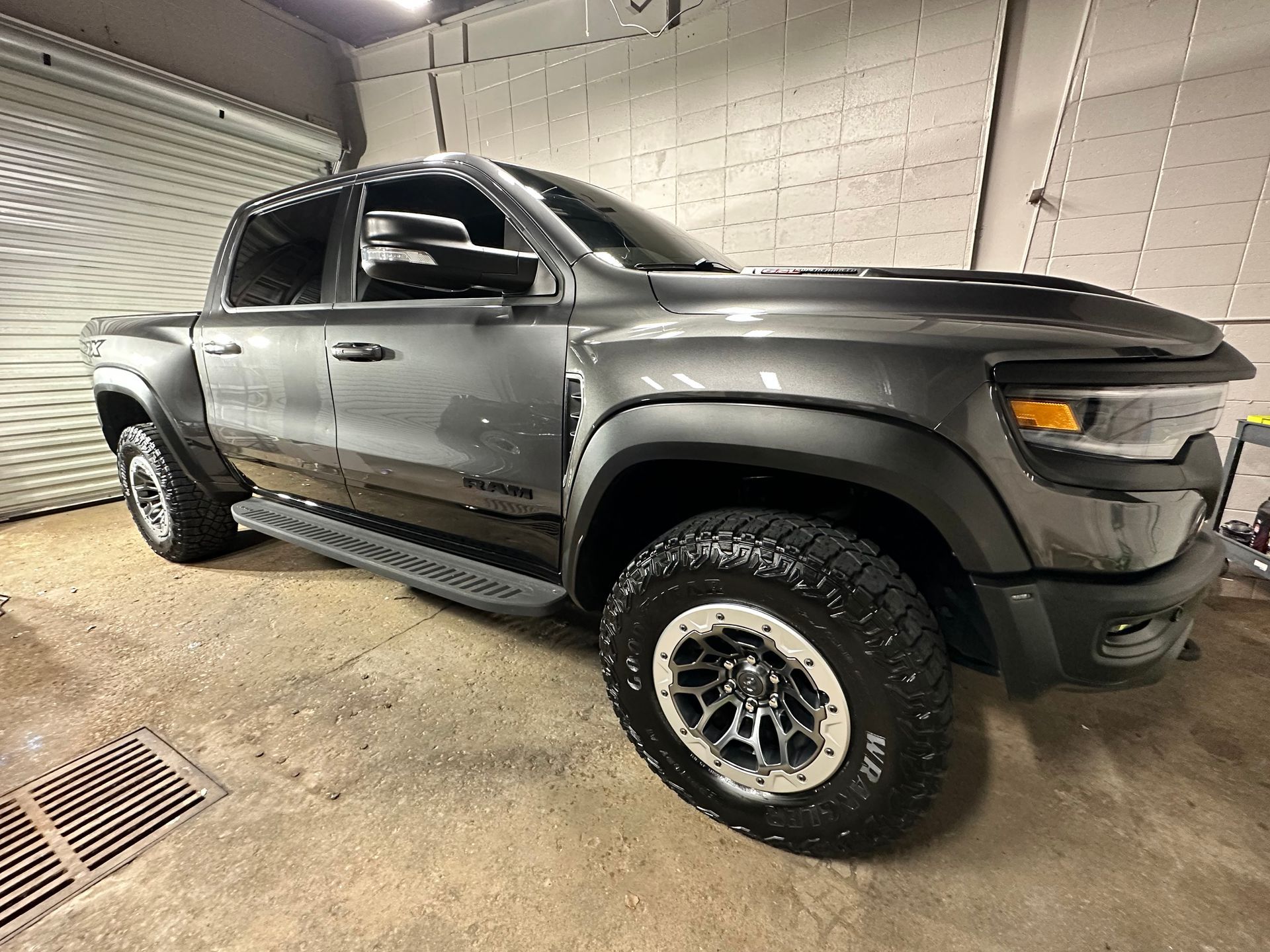 Gray Ram truck with black fender flares parked indoors.