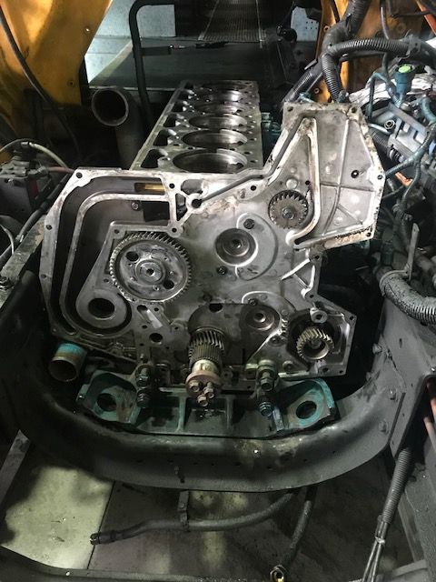 Engine block with exposed gears and components, set in a vehicle.