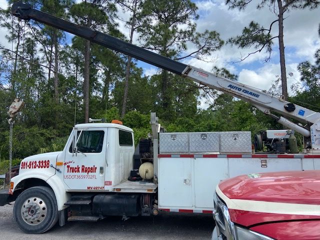 White truck with a crane. Truck has 