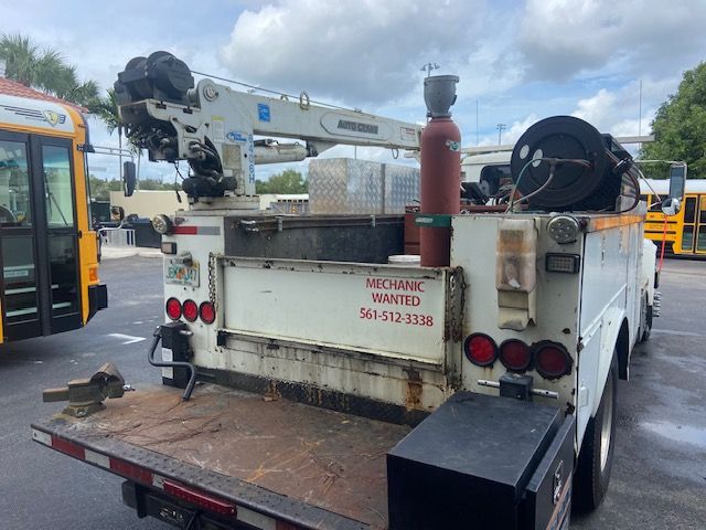 White truck with crane, tools, and 