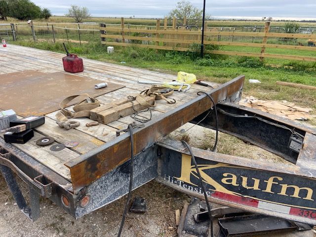 Trailer bed with welding equipment and supplies, rural setting.