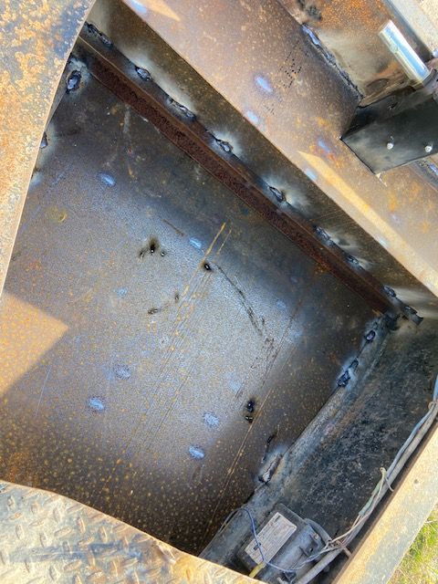 Inside view of a metal structure with weld marks and visible seams.