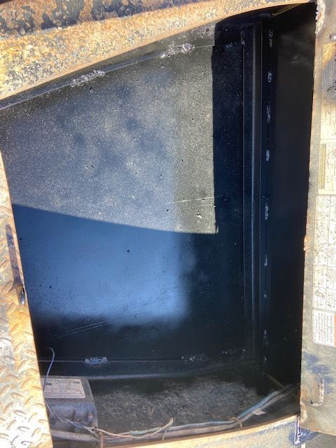 Black metal compartment inside a vehicle, with a diamond plate exterior and visible wiring.