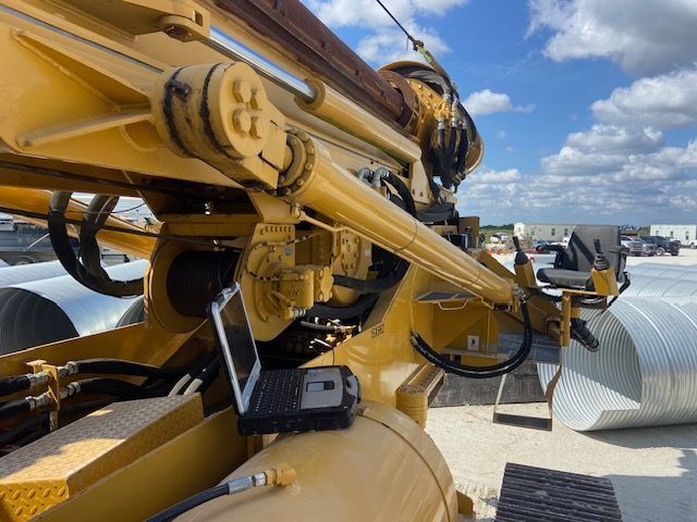 Yellow construction equipment with laptop, outdoors.