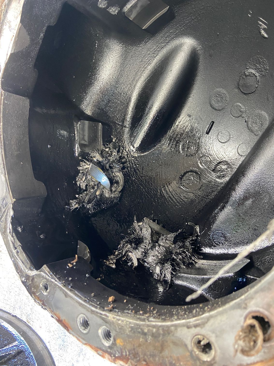 Differential housing interior showing damaged metal fragments and oil.