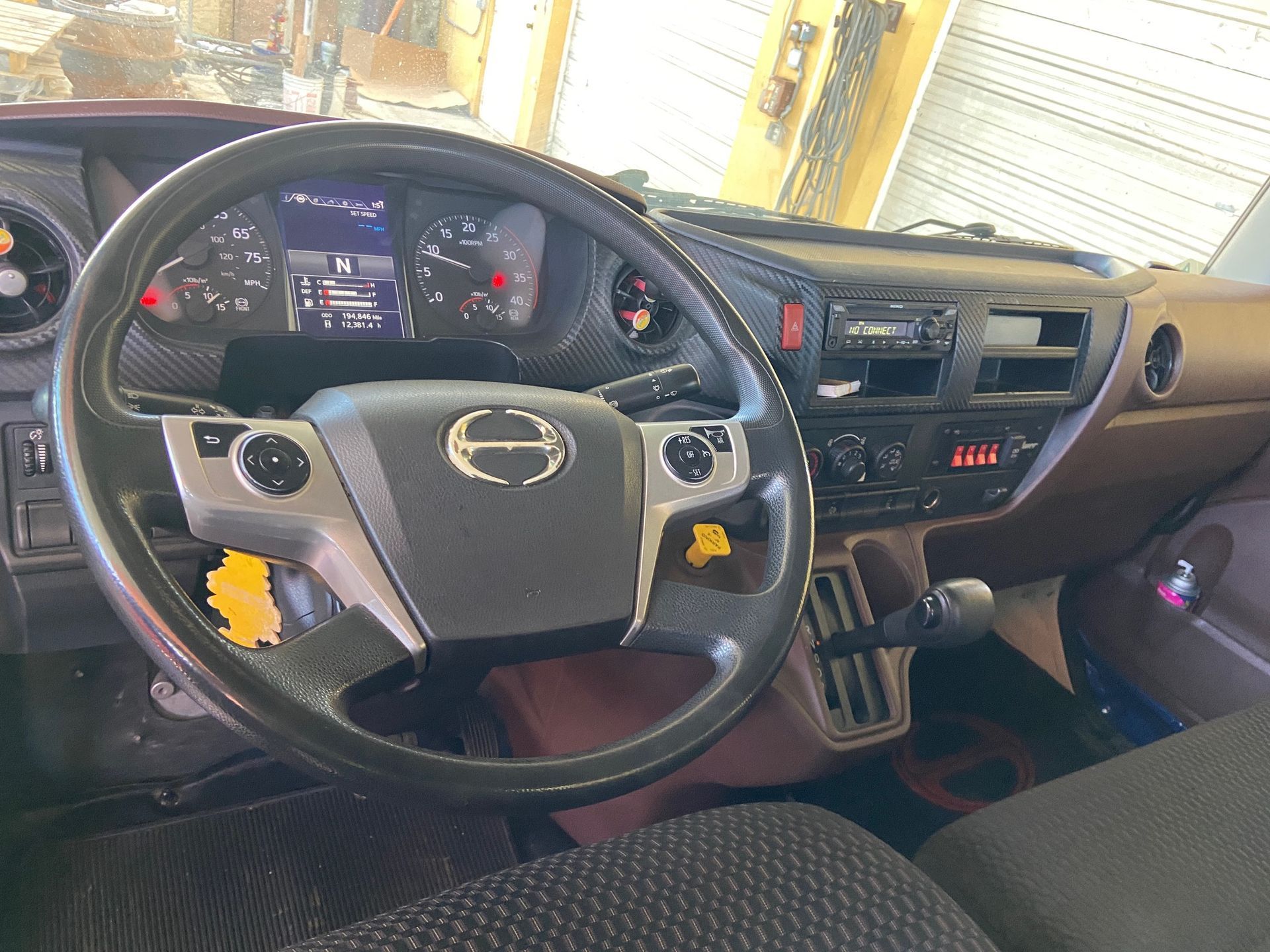 Interior view of a truck cab, with dashboard, steering wheel, and gear shift visible.