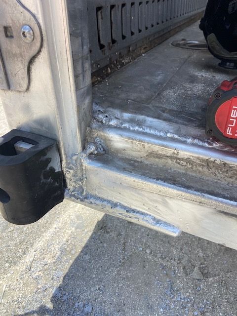 Metal frame of a vehicle door; the bottom edge shows rough welding.