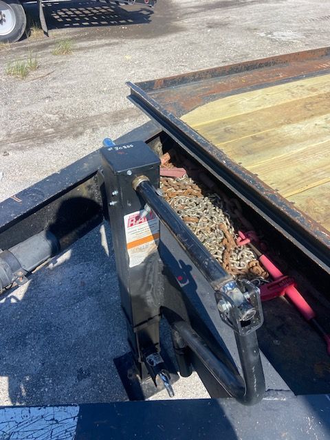 Black trailer jack with chain compartment near the bed.