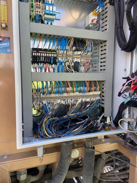 Electrical control panel with numerous colored wires and components.