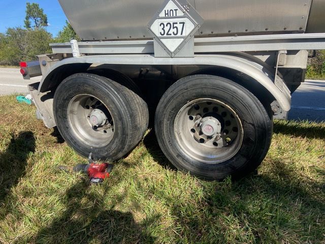 Tanker truck tires on grass with hazard placard 3257, 