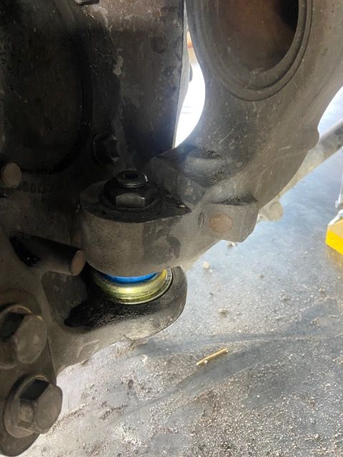 Close-up of car suspension with blue and yellow ball joint.