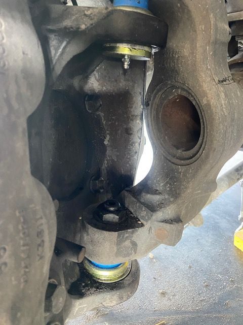 Close-up of car suspension components: ball joints, and a steering knuckle.