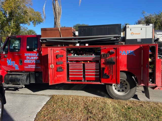 Red service truck with open tool cabinets and equipment.