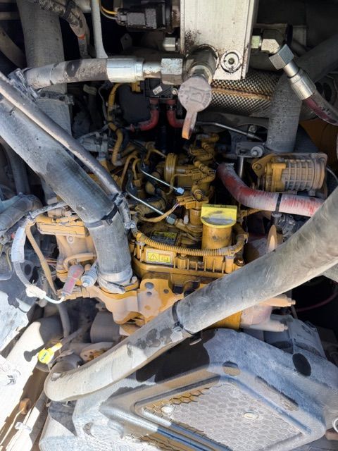 Yellow Caterpillar engine with various tubes and components.