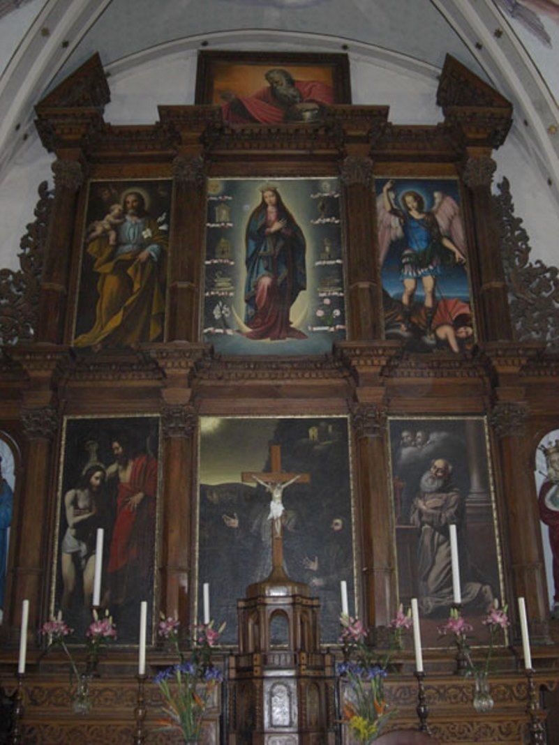 Altare ligneo della chiesa con dipinti di figure religiose.