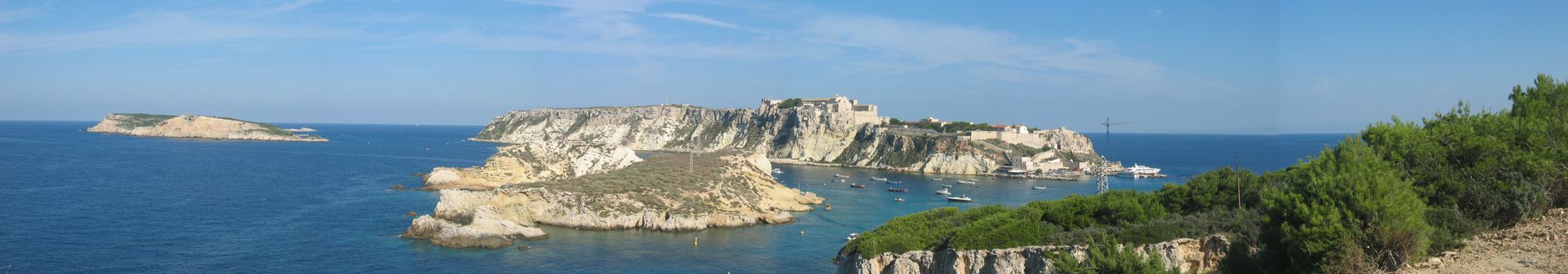 Vista panoramica delle isole nel mare sotto un cielo azzurro, con vegetazione sulla destra.